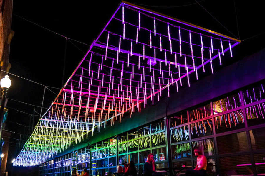 Rainbow light installation hanging between buildings in Georgetown