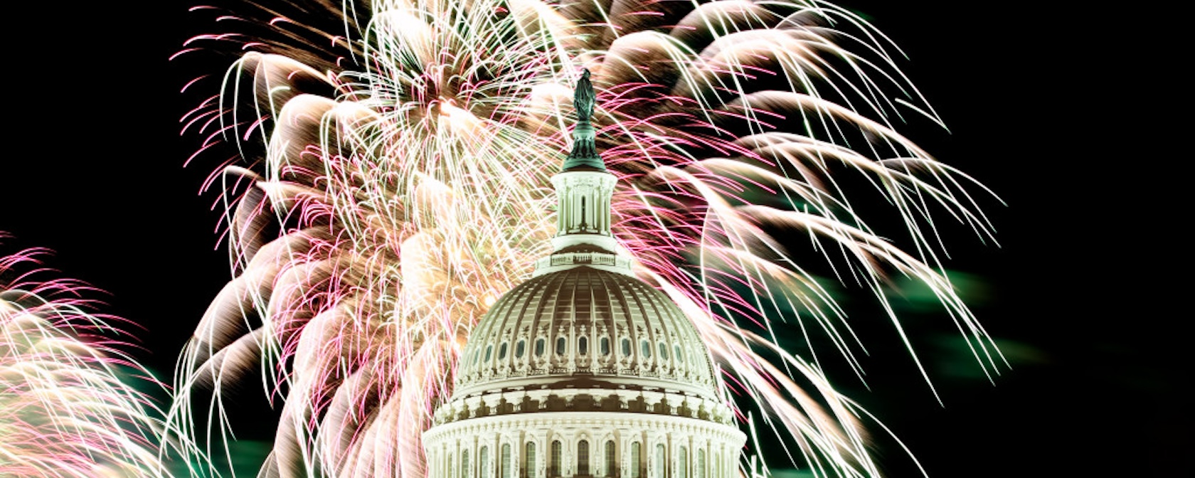  A dazzling fireworks display lights up the night sky above the U.S. Capitol building, showcasing the iconic dome against a backdrop of colorful bursts.