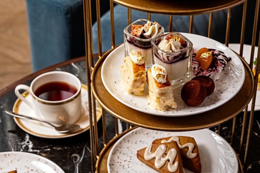 A table set for traditional high tea with plates of scones and pastries.