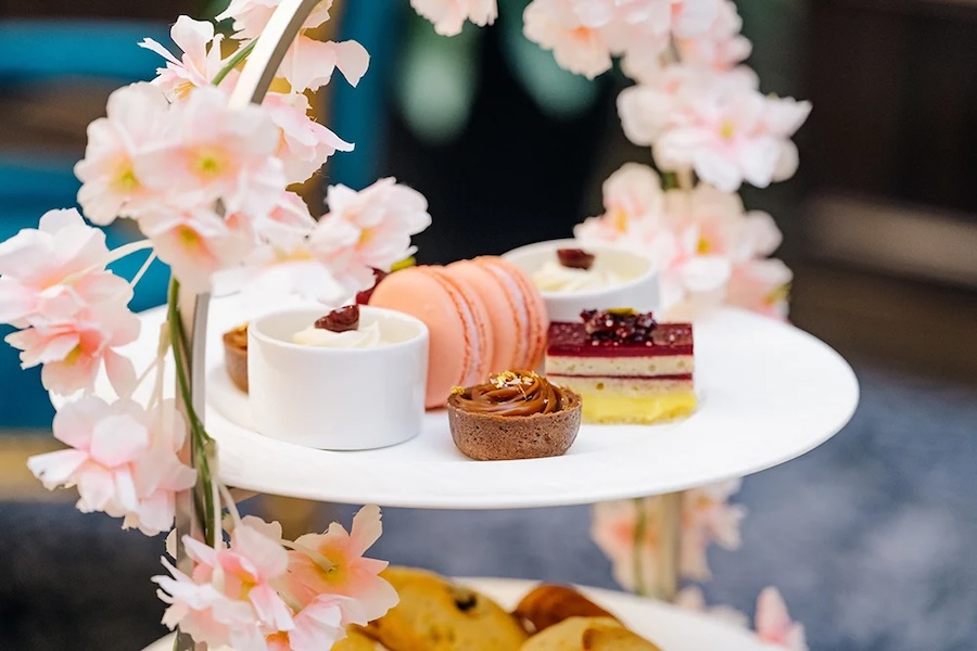 A tiered tray adorned with cherry blossoms holds delicate pastries, macarons and tea treats at the Waldorf Astoria Washington, DC.