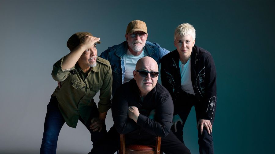 Group portrait of legendary alt-rock band PIXIES posing with casual confidence against a neutral studio backdrop.