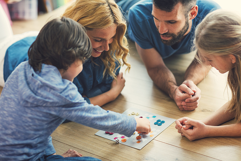 Family on floor playing board game