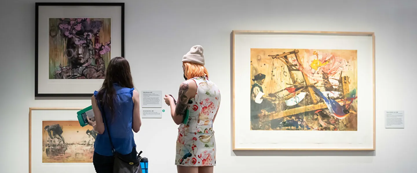 Two people standing in front of art 